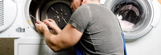 Dryer repair technician fixing a clothes dryer drum in Ann Arbor, MI