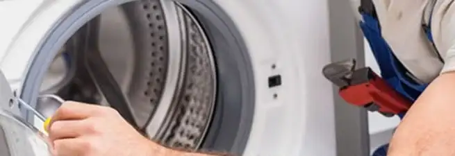 Appliance technician repairing a clothes dryer drum and internal parts in Ann Arbor, MI