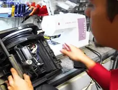 Vacuum repair technician servicing internal components on a workbench in Ann Arbor, MI