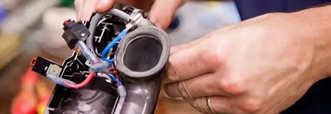 Vacuum repair technician reconnecting wiring and components in Ann Arbor, MI