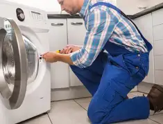 Washing machine repair technician servicing a front-load washer in Ann Arbor, MI
