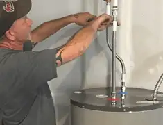 Water heater repair technician tightening supply line connections in Ann Arbor, MI