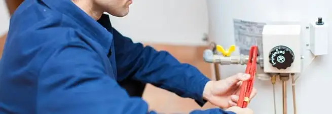 Water heater repair technician adjusting the temperature control and gas valve in Ann Arbor, MI